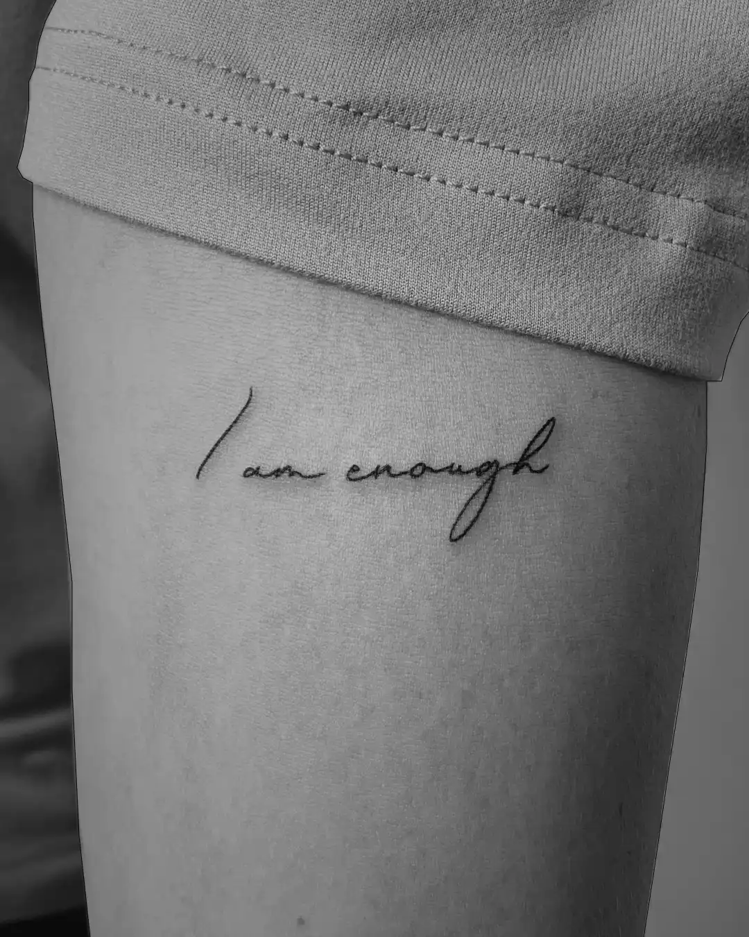 Schriftzug-Tattoo: „I am enough“ in feiner Handschrift auf dem Oberarm