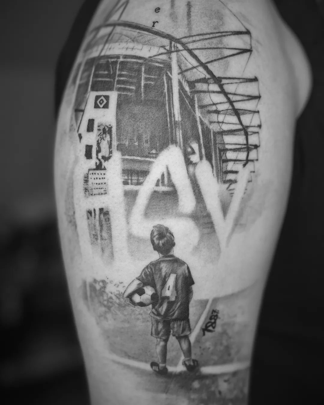 Realistic-Tattoo: Junge mit Fußball und Trikotnummer 4 vor dem Volksparkstadion, mit HSV-Raute und HSV-Schriftzug